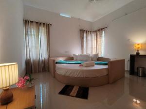 a bedroom with a large bed and a couch at Ant Homes by Afrind Hospitality in Cochin