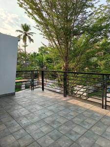 a balcony with a black fence and a tree at Ant Homes by Afrind Hospitality in Cochin