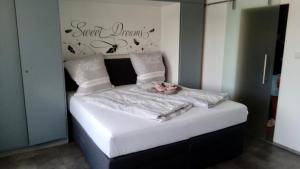 a bed with white sheets and a flower on it at Sweet Dreams Wellness Appartement in Seefeld in Tirol