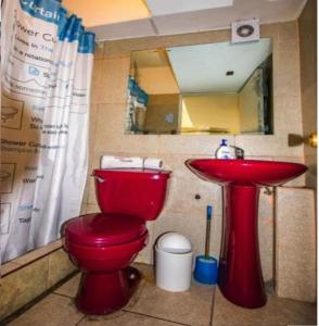Un baño con un inodoro rojo y un lavabo. en BahiaCaracoles Apart, en Antofagasta 23 fotos más