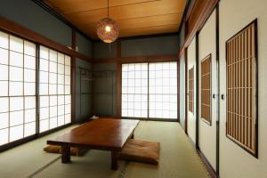 Habitación con mesa de madera y ventanas grandes. en 貸切民泊宿 だんねだんね Private guest house Danne-Danne en Ōno