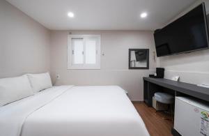 En eller flere senge i et værelse på Gwanganli Calm Rest Hotel