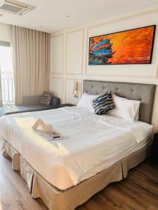1 cama grande en un dormitorio con una pintura en la pared en Ks View Biển Bể Bơi Dát Vàng GOLDENBAY ĐÀ NẴNG, en Da Nang