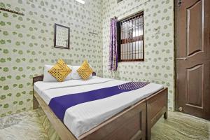 a bedroom with a bed and a window at SPOT ON Ams Annex in Chennai