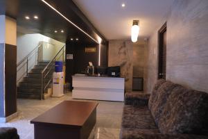 a lobby with a couch and a table and stairs at Nakshatra grand in Tirupati