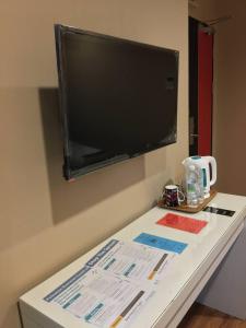 a table with a flat screen tv on a wall at M BOUTIQUE INN (BINTANG JAYA) in Miri