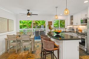 a kitchen with a large island with a table and chairs at Cute 2BR Cottage w AC close to beaches in Koloa