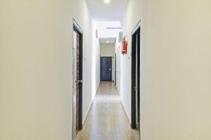 a hallway with white walls and a blue door at OYO Flagship A Delight Residency in Hyderabad
