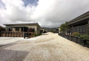 a house with a gravel driveway next to a building at Country Retreats on Ranzau 1 in Nelson