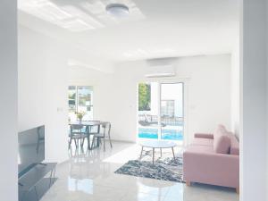 a living room with a pink couch and a table at White Mountain Pool Villas in Paphos City