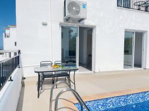 a patio with a table and chairs on a balcony at White Mountain Pool Villas in Paphos City