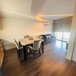 a dining room with a table and chairs and a couch at Vacation Condo 1 bedroom in Tijuana