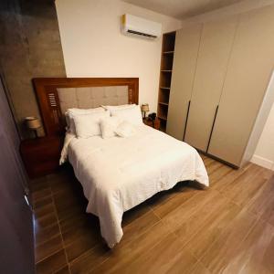 Schlafzimmer mit einem Bett mit weißer Bettwäsche und Kissen in der Unterkunft Vacation Condo 1 bedroom in Tijuana