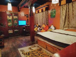 a bedroom with a bed and a desk with a television at Shambhala Palace Hotel in Lhasa