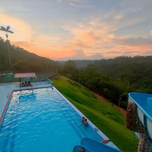 a large swimming pool with a sunset in the background at Quinta Felicidad in Pedro Vicente Maldonado