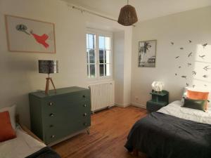 ein Schlafzimmer mit einem Bett und einer Kommode mit Vögeln an der Wand in der Unterkunft Gîte Garralda Pays Basque 6 pers in Saint-Esteben