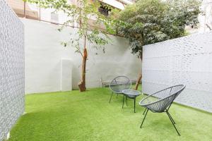 two chairs and a table on a yard with grass at Snug studio apartment with pvt garden access III in Athens