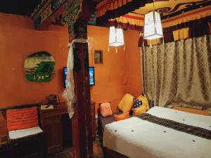 een slaapkamer met een bed, een bureau en een computer bij Shambhala Palace Hotel in Lhasa