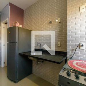 Apartamento Top Barra da Tijuca في ريو دي جانيرو: مطبخ مع كونتر وثلاجة