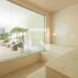 a bathroom with a large window with plants in it at Apartamento Top Barra da Tijuca in Rio de Janeiro