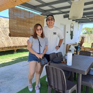 een man en een vrouw die naast een tafel staan bij The Beaulah Overlooking Cozy Hideaway in Hundred Islands in Alaminos