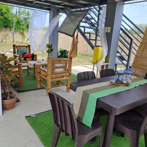 een patio met een tafel en stoelen op het gras bij The Beaulah Overlooking Cozy Hideaway in Hundred Islands in Alaminos
