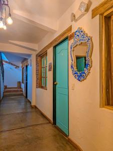 a hallway with a blue door and a mirror on a wall at La Rosa Nautica Hostel in Guaduas