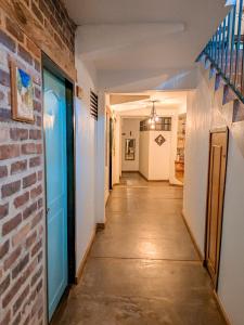 a hallway with a brick wall and a blue door at La Rosa Nautica Hostel in Guaduas