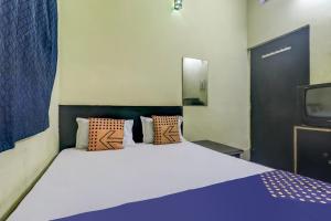 ein Schlafzimmer mit einem großen Bett und einem TV in der Unterkunft SPOT ON Hotel New Diamond in Jamshedpur