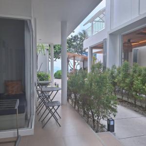 un balcón de una casa con mesa y sillas en Baanfah Resort Samui en Mae Nam Beach