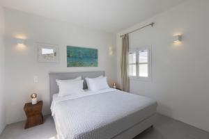 ein weißes Schlafzimmer mit einem Bett und einem Fenster in der Unterkunft Villa Alkyoni · Beautiful 8-person Family Villa with Great Views in Naoussa + 34 Fotos