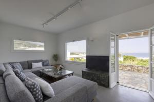 ein Wohnzimmer mit Sofa und Fernseher in der Unterkunft Villa Alkyoni · Beautiful 8-person Family Villa with Great Views in Naoussa