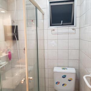a bathroom with a shower and a toilet with a television at Meu Cantinho in Campinas