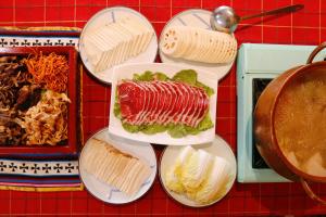 una mesa cubierta con platos de comida con un sándwich en 九寨沟阿布氇孜民宿Jiuzhaigou Valley Abluzi B&B, en Jiuzhaigou