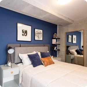 a bedroom with a large bed with blue walls at N8 Loft estilo Industrial en Ciudad de Guatemala in Guatemala