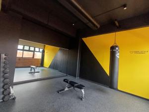 a gym with a black and yellow wall and a dumbbell at N8 Loft estilo Industrial en Ciudad de Guatemala in Guatemala