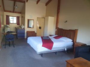 ein Schlafzimmer mit einem großen weißen Bett mit einer roten Decke in der Unterkunft Geraldine Motels in Geraldine