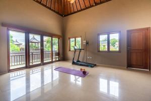 une salle de sport avec un tapis de yoga et un tapis de course dans l'établissement THE ROSE VILLA, à Jimbaran