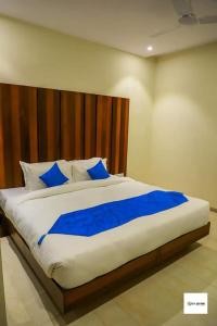 a large bed with blue pillows in a bedroom at Hotel City Star - Agra in Agra