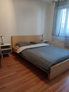 a bedroom with a bed and two night stands at Appartement cosy à Strasbourg in Strasbourg