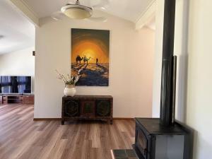a living room with a fireplace and a painting on the wall at Aircabin｜KANGY ANGY｜Lovely｜4 Beds Holiday House in Tuggerah