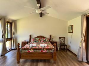 Aircabin｜KANGY ANGY｜Lovely｜4 Beds Holiday House في Tuggerah: غرفة نوم بسرير ومروحة سقف
