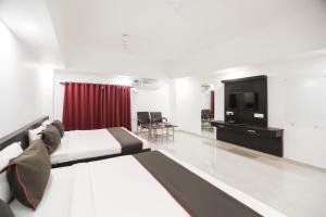 a hotel room with a bed and a television at Collection O Hotel Belmorrise in Noida