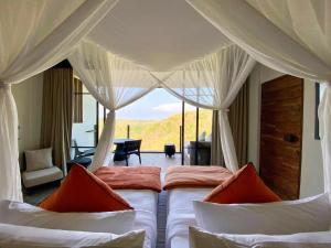 - une chambre avec 2 lits et une vue sur une pièce dans l'établissement MAUA Nusa Penida Bali, à Nusa Penida