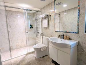uma casa de banho com um chuveiro, um WC e um lavatório. em Macchi Hotel - Taipei em Taipei
