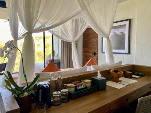 a bedroom with two beds with curtains and a desk at MAUA Nusa Penida Bali in Nusa Penida