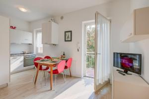 cocina y comedor con mesa y sillas rojas en Casa al Cor Apartments - Happy Rentals, en Nago-Torbole