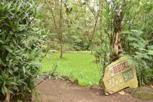 een bord midden in een tuin met een parkaanbieding bij Room in BB - Red Rocks Rwanda - Tent Twin in Nyakinama
