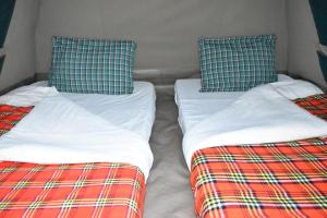 2 aparte bedden naast elkaar in een kamer bij Room in BB - Red Rocks Rwanda - Tent Twin in Nyakinama
