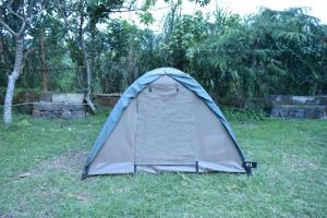 een tent in het gras in een veld bij Room in BB - Red Rocks Rwanda - Tent Twin in Nyakinama